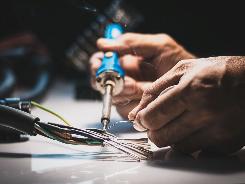 electrician-using-a-soldering-iron-to-connect-the-wires