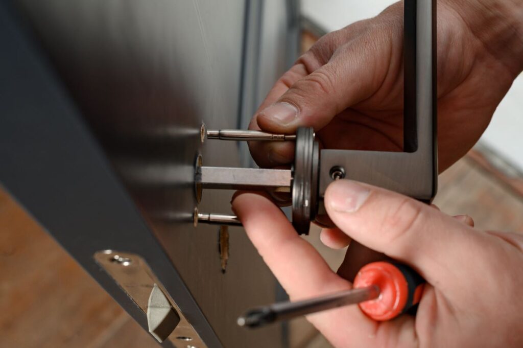 man-installs-a-doorknob-in-a-door-carpentry-at-home